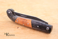 Folding knife with its black and brown wood handle