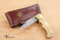 Click to open folding knife with its Damascus blade